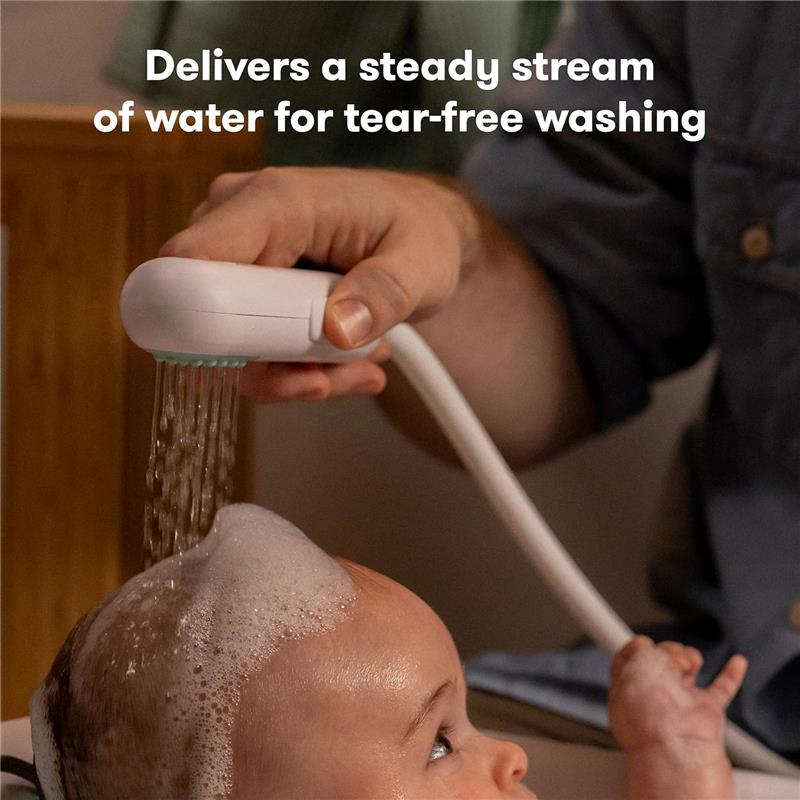 Fridababy bathtub sprayer attachment in use, delivering water to a baby’s head for gentle washing, with text stating benefits.