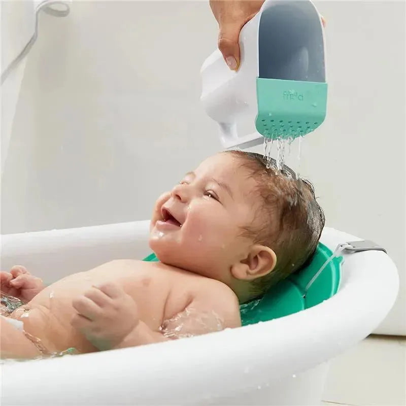 Baby enjoying a bath as water flows from the Fridababy Control The Flow Rinser, designed for rinsing hair gently.