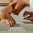 Hands of an adult applying FridaBaby Fart Freeing Essentials on a baby to relieve gas and calm colic.