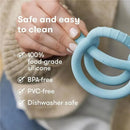 Muted blue FridaBaby Get-A-Grip teether held in a hand, featuring text on safety and cleaning features in the background.