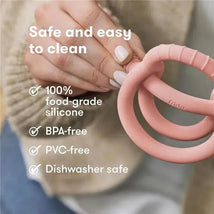 Muted pink teether from FridaBaby, made of 100% food-grade silicone; features include BPA-free, PVC-free, and dishwasher safe.
