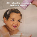 Lavender Baby & Kids Bubble Bath and Body Wash being poured over a smiling child in a bubbly bath.