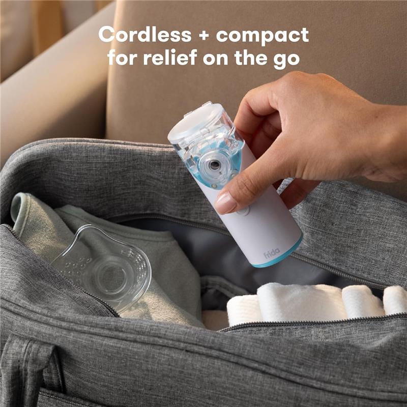 Ultra-quiet portable nebulizer in hand, being removed from a grey bag with a shirt and towels visible inside.