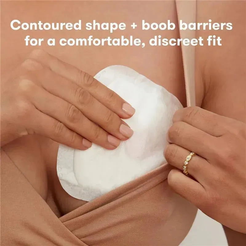 Disposable nursing pad being applied to skin, highlighting its contoured shape and features for comfort and discretion.