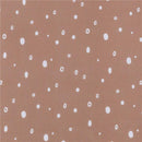 Baby unisex knit crib sheet featuring a boho rainbow design with a brown background and scattered white dots.