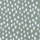 Knit crib sheet featuring a Dino Time pattern with a light green background and scattered white shapes.
