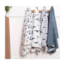 Four flannel blankets hanging on a wooden rod, featuring whale and nautical-themed patterns in soft colors.
