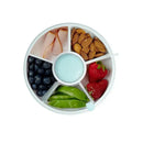 Snack spinner with six compartments filled with blueberries, strawberries, almonds, turkey slices, green peas, and a dipping cup.