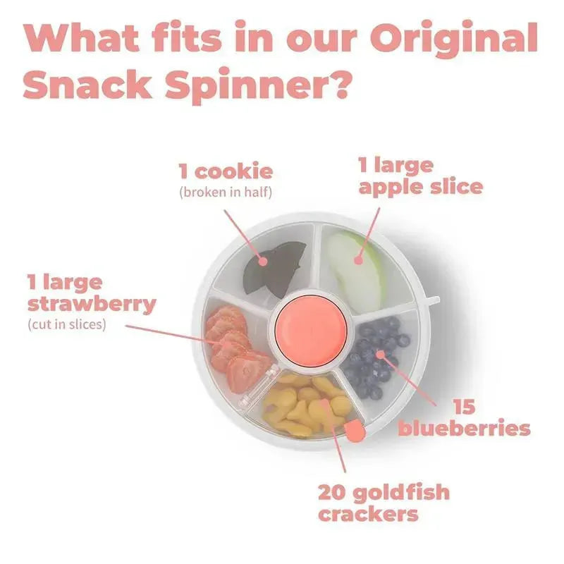 A snack spinner with sections labeled for various healthy snacks: half a cookie, a large apple slice, a large strawberry, blueberries, and goldfish crackers.