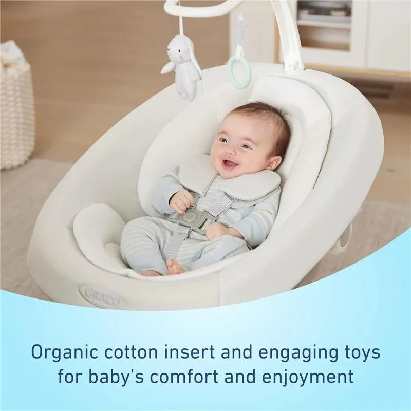 Graco Smartsense Swing with Cry Detection, featuring a smiling baby in an organic cotton insert and engaging toys.