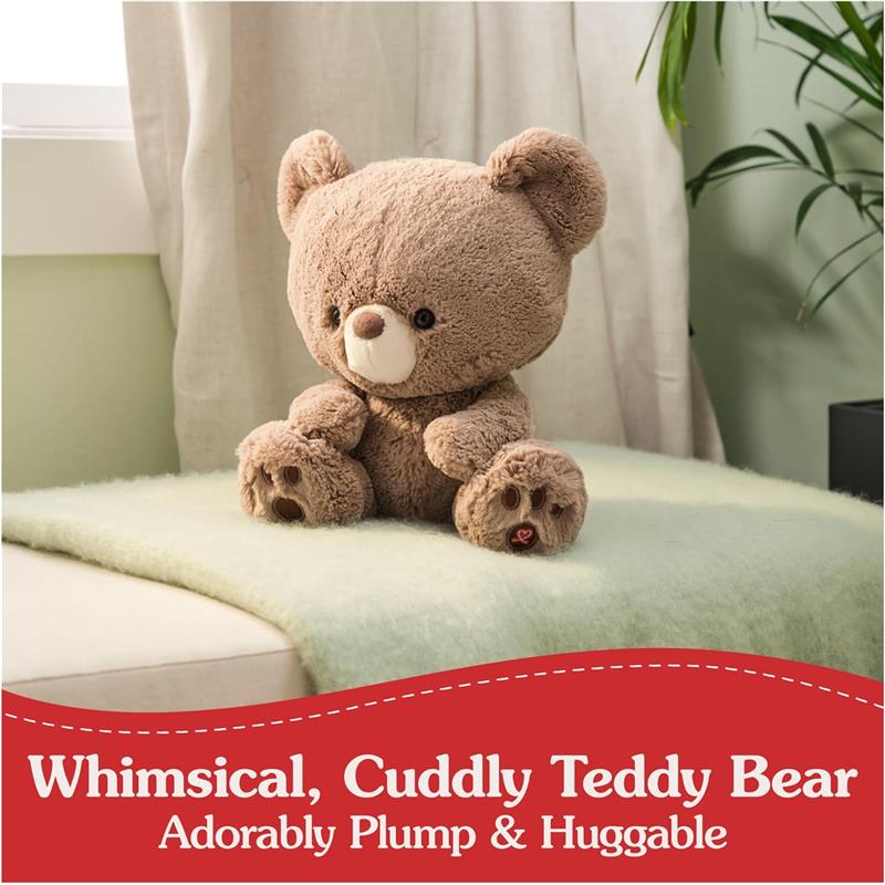 Plush brown teddy bear with a round face and small nose, sitting on a green blanket with a playful, cuddly design.