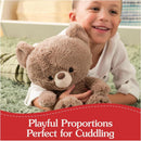 A smiling child hugs a soft, brown stuffed bear, highlighting its cuddly features and playful proportions.