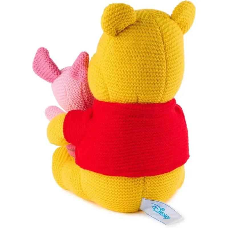 Knit plush Winnie the Pooh wearing a red shirt and holding Piglet, both made of colorful yarn.