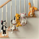 Colorful stuffed animals, including a cat, dog, and a yellow dog, hanging on a staircase railing.