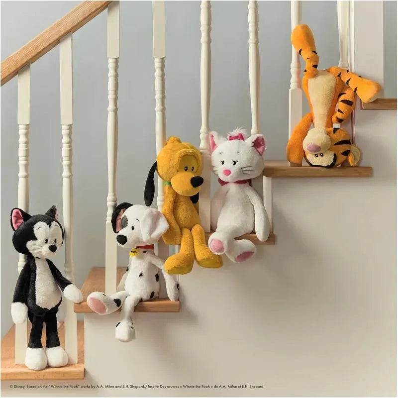 Five colorful plush toys, including a black cat, a dog, a yellow dog, a white cat with a pink bow, and Tigger, hang playfully on a staircase railing.