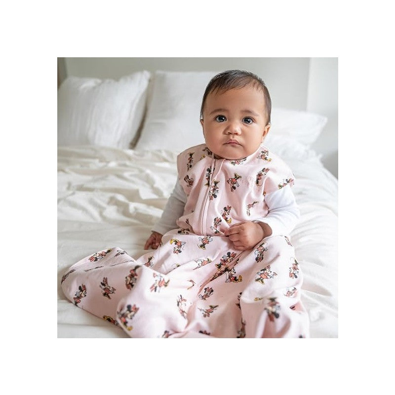 Large HALO SleepSack Wearable Blanket in pink with Minnie Mouse prints, worn by a baby sitting on a bed.