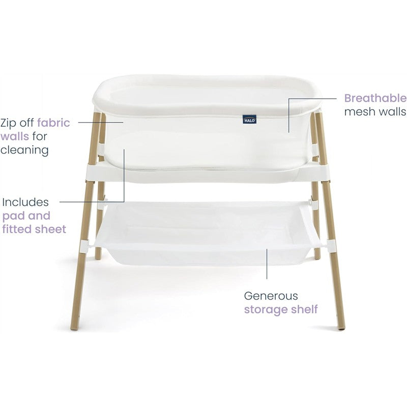 HALO BassiNest Essential Sleeper in white with zip-off fabric walls, breathable mesh sides, included padded sheet, and storage shelf.