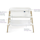 HALO BassiNest Essential Sleeper in white with zip-off fabric walls, breathable mesh sides, included padded sheet, and storage shelf.
