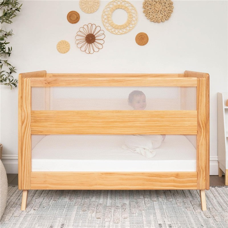 HALO Full-Size Fitted Crib Sheets 2-Pack - White, displayed with a wooden crib featuring mesh sides and a baby swaddled inside.