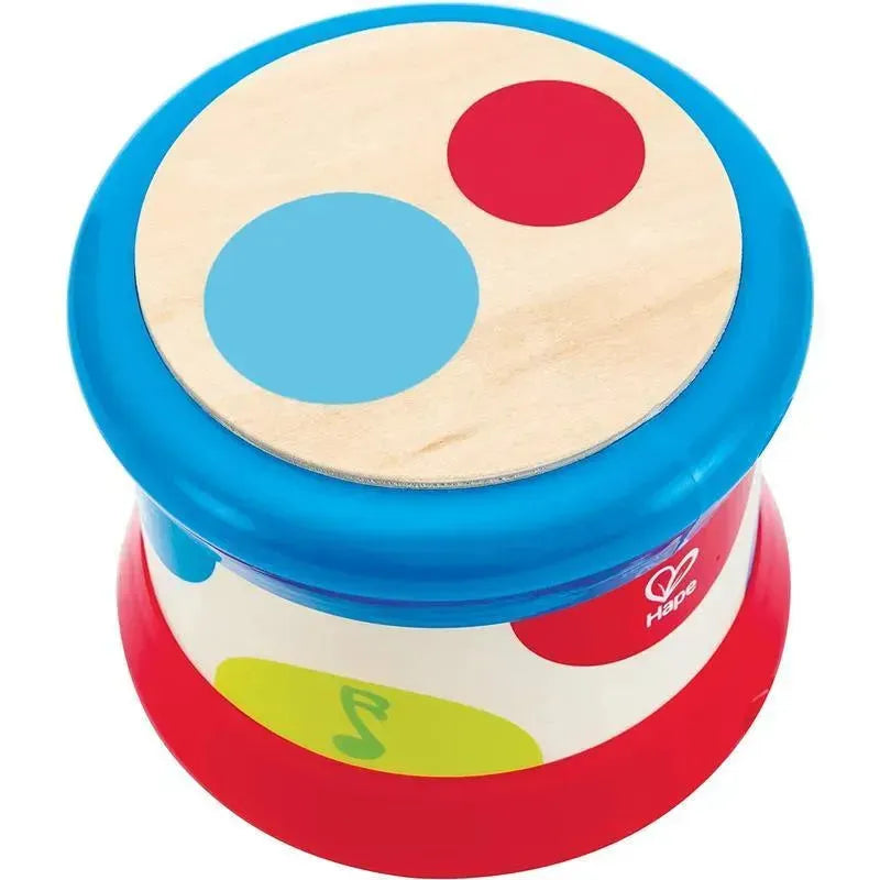 Colorful Hape baby drum with a wooden top featuring blue and red circles, designed for young children to encourage musical play.