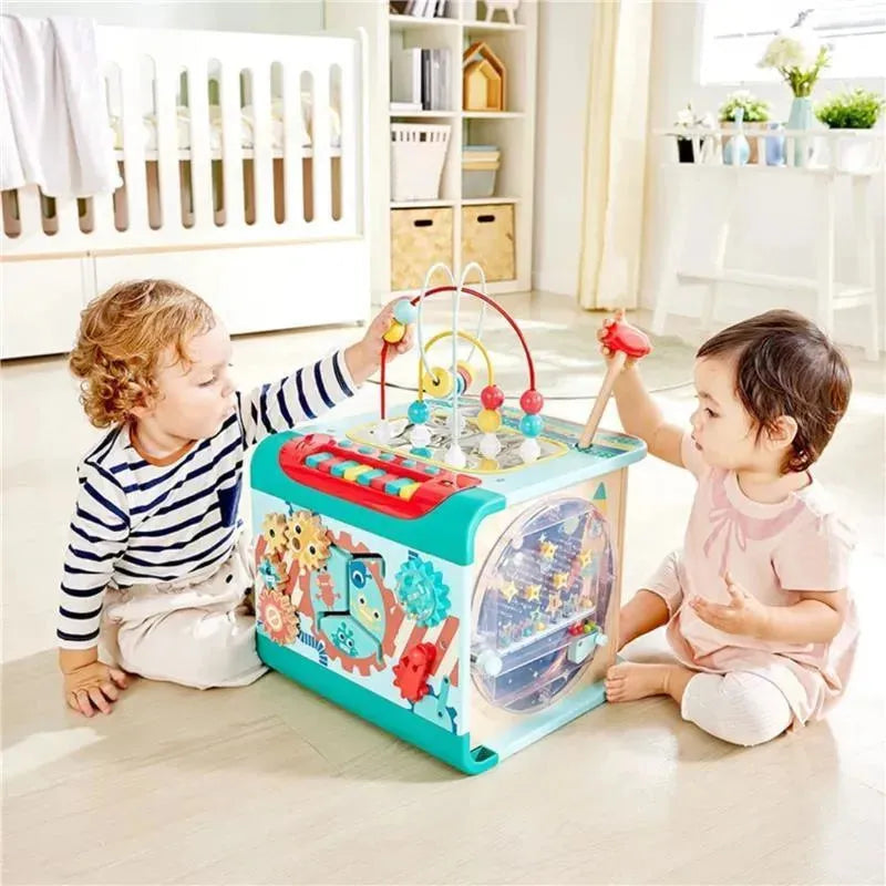 Children playing with the Hape Explore and Learn Magic Cube Montessori toy, featuring colorful interactive elements.