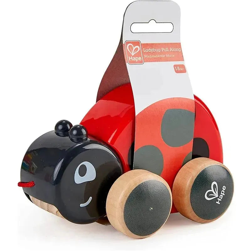 Hape Ladybug Pull Along toy with a red body, black head, and wooden wheels, designed for children 18 months and up.