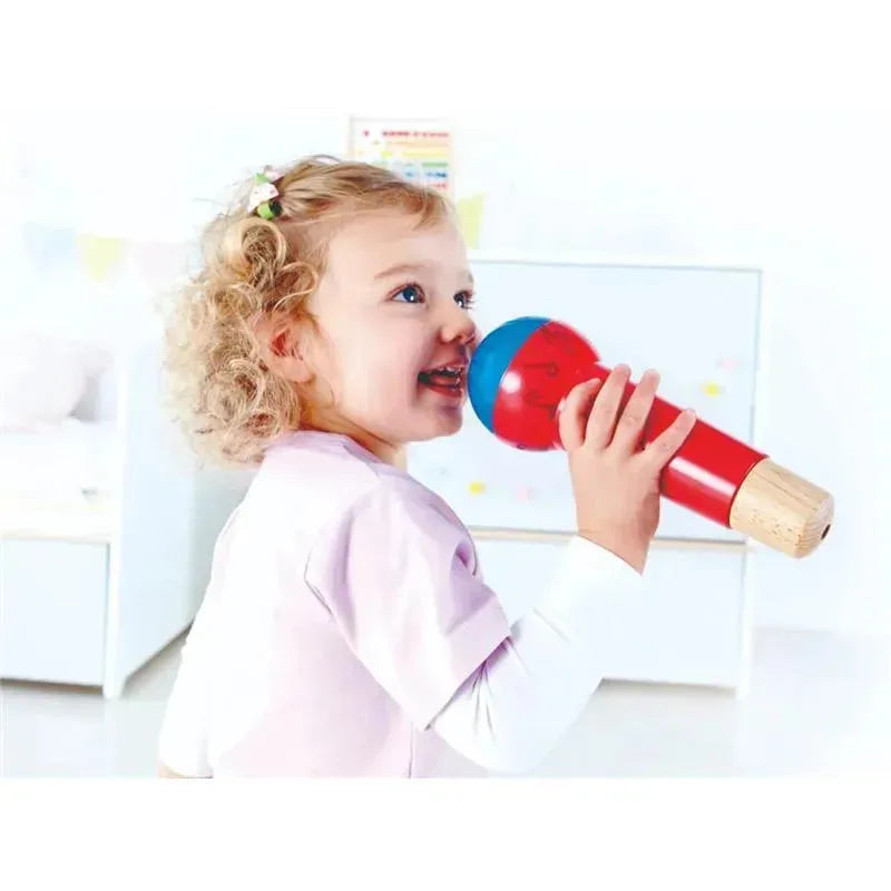 Child joyfully holding a red and blue Hape Mighty Echo Microphone, smiling while engaging in play.