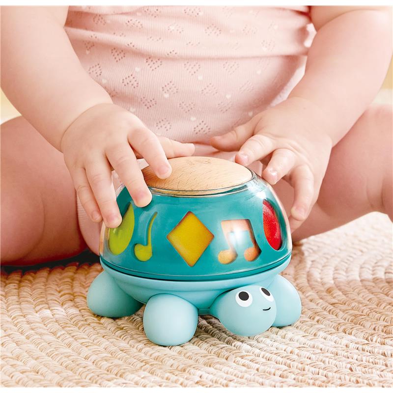 Hape Music Turtle, a colorful musical toy, with a wooden top and playful designs, being used by a baby.