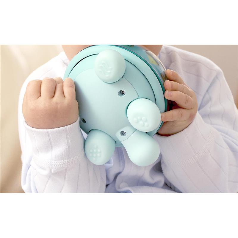 A toddler holds a light blue Hape Music Turtle toy, featuring rounded legs and a colorful musical dome.