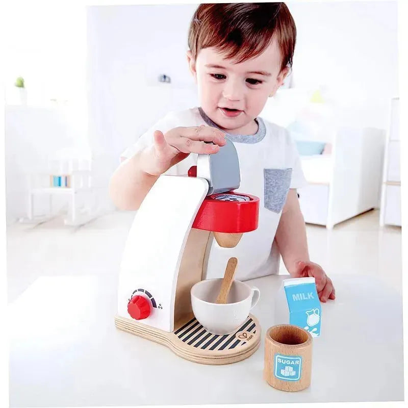 Child interacting with the Hape My Coffee Machine wooden play kitchen set, which includes coffee maker, cup, sugar, and milk.