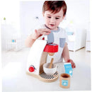 Child interacting with the Hape My Coffee Machine wooden play kitchen set, which includes coffee maker, cup, sugar, and milk.