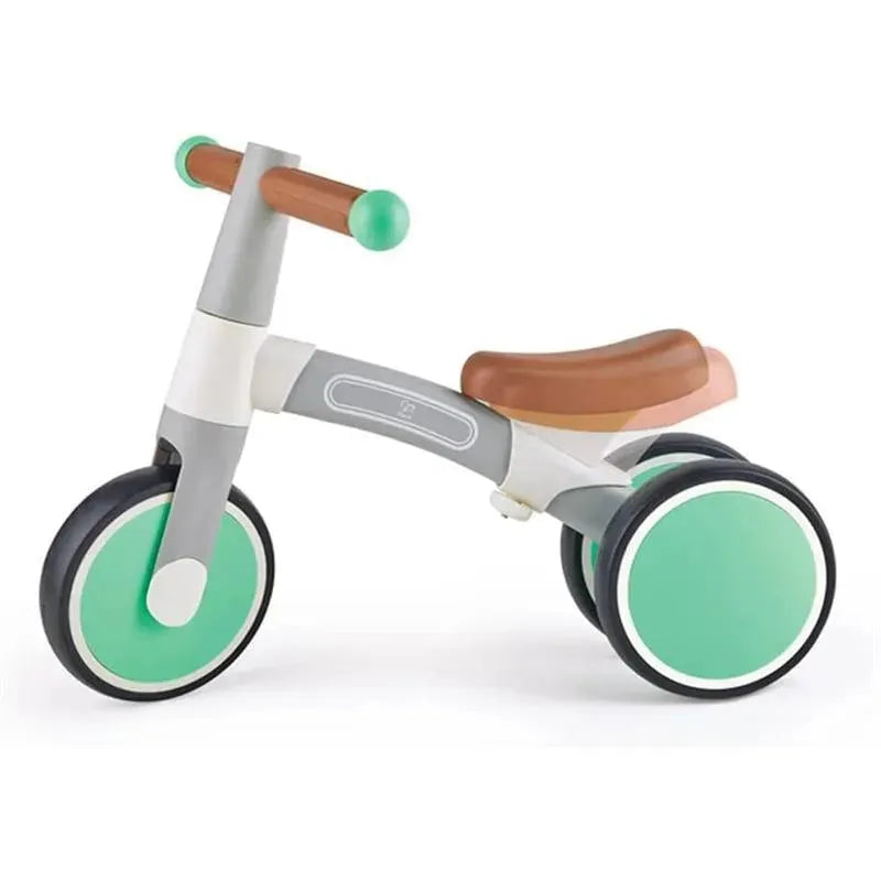 Balance bike in Vespa Green color with a brown seat, designed for toddlers with two large wheels and handles.