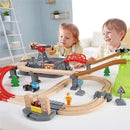 Children interact with the Hape Railway Bucket Builder Set, featuring wooden tracks, a crane, and vehicles on a playtable.