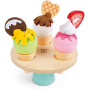 Colorful wooden ice cream set by Hape featuring three scoops in cones, with toppings and a spinning base.