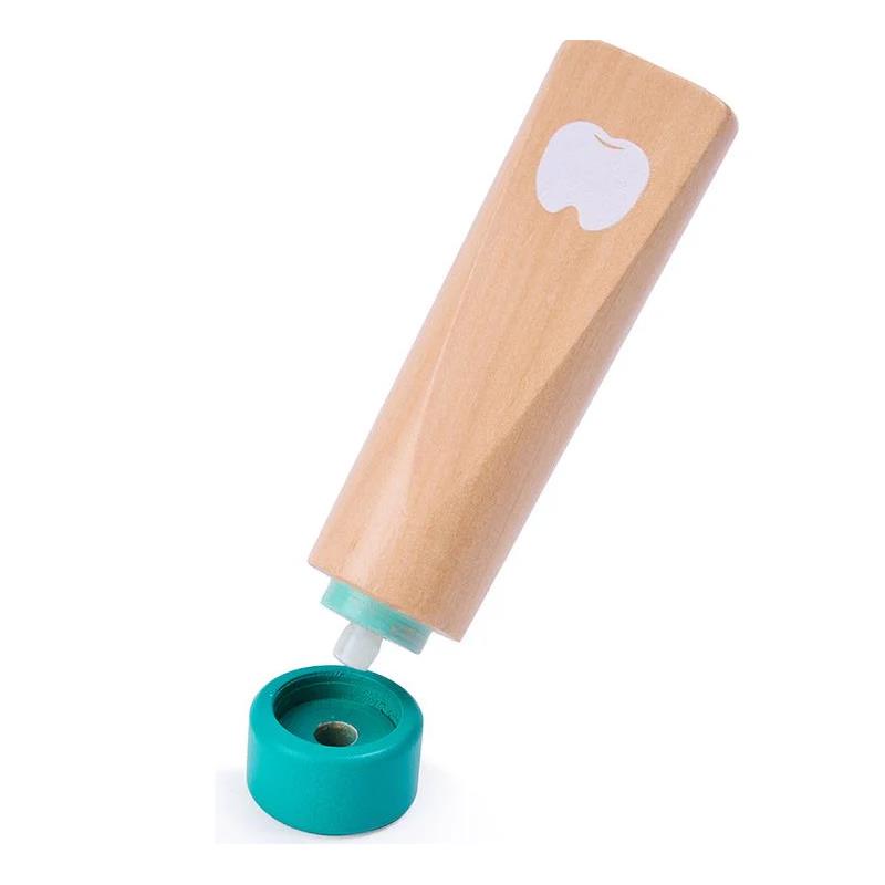 Wooden toothpaste tube with a green cap, part of the Hape Super Smile Dental Clinic Set for imaginative play.