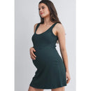 Ribbed maternity active mini dress in hunter green, being modeled by a pregnant woman with a confident pose.