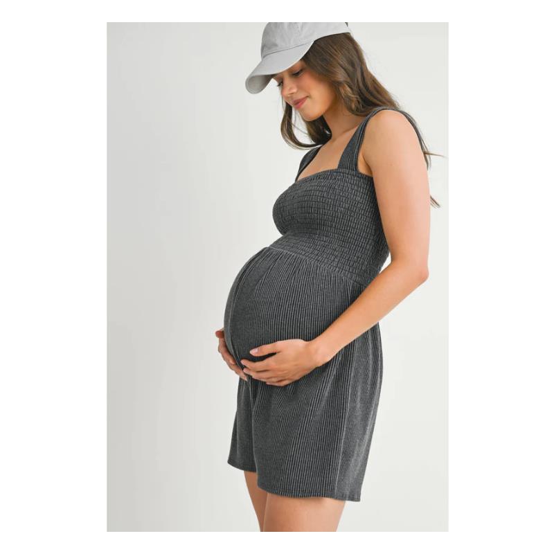 Charcoal ribbed smocked maternity knit romper worn by a pregnant woman, gently cradling her belly.