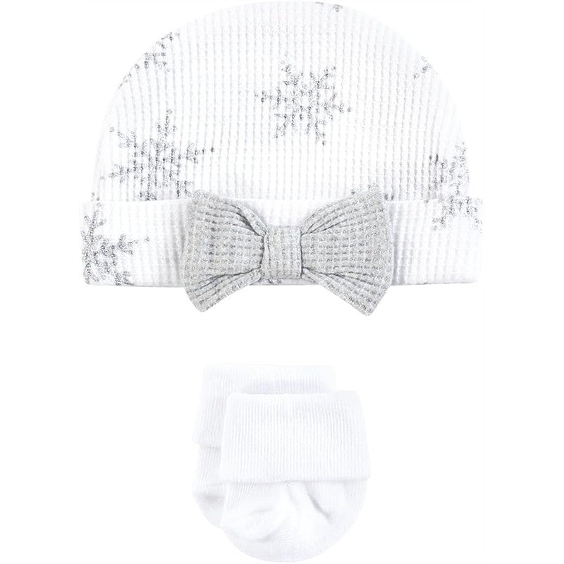 White thermal hat with snowflake design and bow, accompanied by matching white booties.