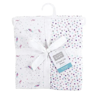 Unisex baby cotton fitted crib sheets featuring unicorn and polka dot designs, packaged with a ribbon.