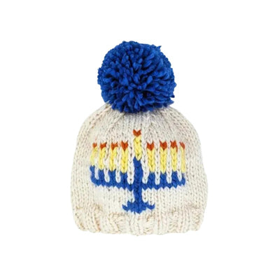 Menorah beanie hat for babies and kids, cream color with blue pom-pom and colorful menorah design.