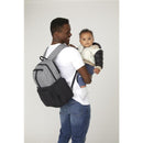 HUGGIES Day Pack Diaper Backpack in Bridal Rose/Two Tone on a man’s back, holding a baby dressed in a light jacket.