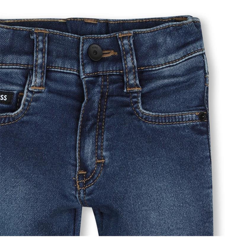 Denim pants for boys by Hugo Boss in a dark wash with contrasting stitching and a front button closure.