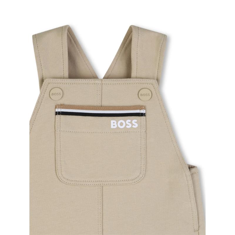 Infant cotton shortalls in stone color by Hugo Boss with adjustable straps and a front pocket featuring the logo.