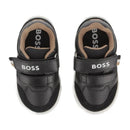 Black Hugo Boss baby boy trainers with dual Velcro straps and tan accents, designed for casual wear.