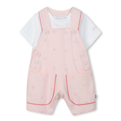 Hugo Boss baby girl dungarees in light pink with a white t-shirt, featuring button closures and decorative pockets.