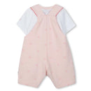 White t-shirt under pink dungarees featuring a subtle logo pattern, suitable for baby girls.