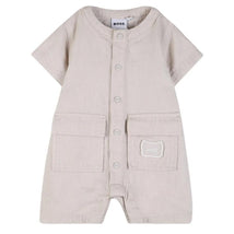 Ivory short sleeve linen romper for infants by Hugo Boss, featuring front buttons and two front pockets.