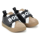 Black and tan Hugo Boss baby sneakers featuring a velcro strap and white logo on the front.