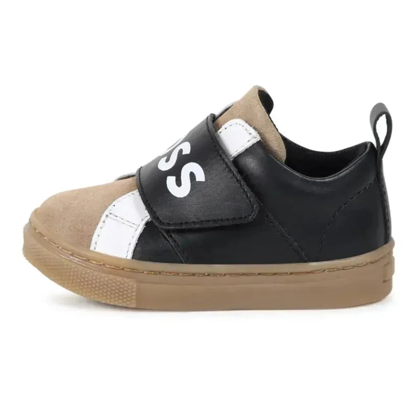Black and beige Hugo Boss Baby sneakers made of leather and mesh, featuring a Velcro strap and branding.