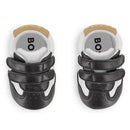 Soft black sheep leather slippers for babies by Hugo Boss, featuring Velcro straps and a stylish design.